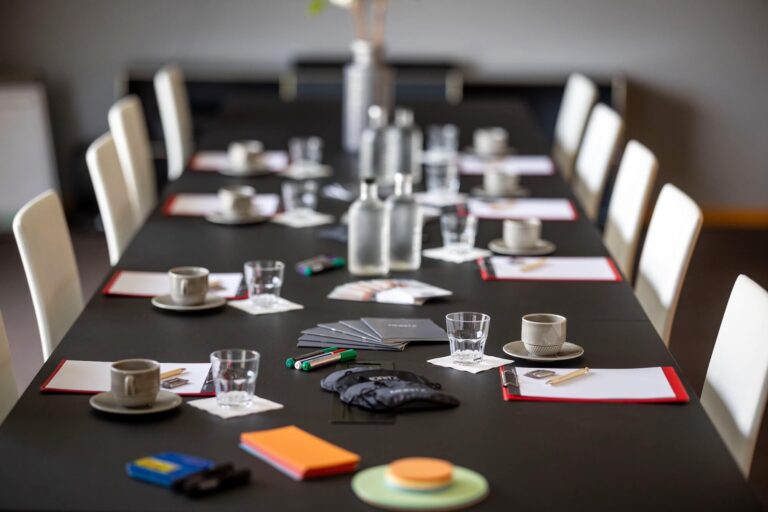 Langer Tisch gedeckt mit Workshopmaterialien